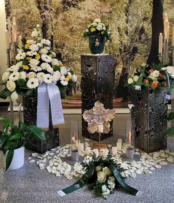 Würdevolle Trauerfeier mit Kerzenlicht und Blumen arrangiert von Bestatter Halle